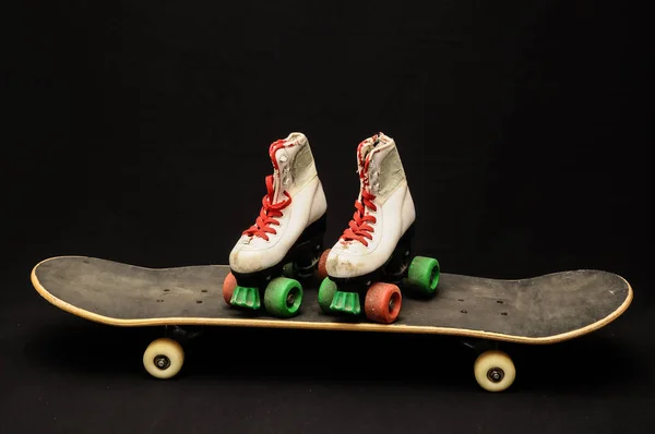 ヴィンテージスタイルブラックスケートボードと暗い背景のスケートブーツ — ストック写真