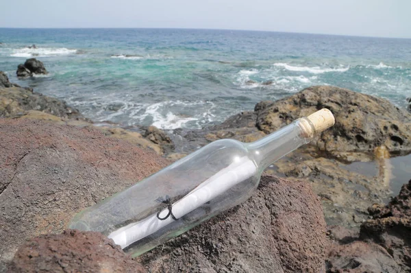 Message in the Bottle on the Rocks near the Beach