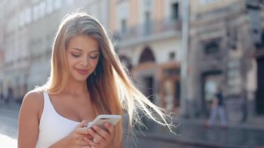 Güzel Avrupa şehirde yürüyüş smartphone kullanan genç kadın. Ağır çekim. Internet tarama, haritalar ve bilgi arama, iletişim kız. Seyahat