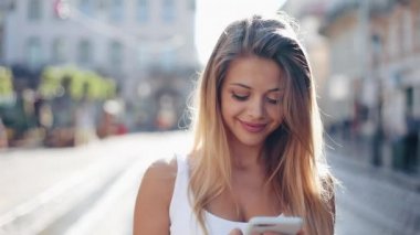 Avrupa şehirde Smartphone kullanan genç kadın. Ağır çekim. Internet tarama, haritalar ve bilgi arama, iletişim güzel kız. Seyahat