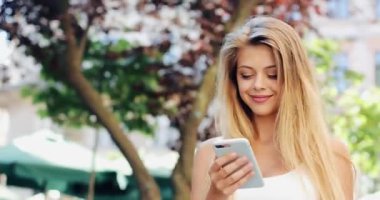 Güzel Avrupa şehirde yürüyüş smartphone kullanan genç kadın. Ağır çekim. Internet tarama, haritalar ve bilgi arama, iletişim kız. Seyahat