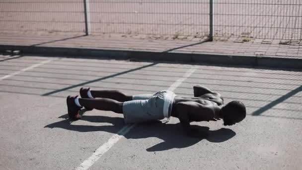 Homem afro-americano atlético a fazer flexões. Treino cruzado. Treino, fitness, corrida, motivação . — Vídeo de Stock