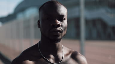 Kendinden emin ve kızgın Afrikalı-Amerikalı adam kameraya - açık arıyor. Uyuşturucu kaçakçısı, tutuklu veya suç adam bir kılavuz karşı ayakta. Yasadışı, cinayet, suç, hırsızlık, uyuşturucu. Yakın çekim