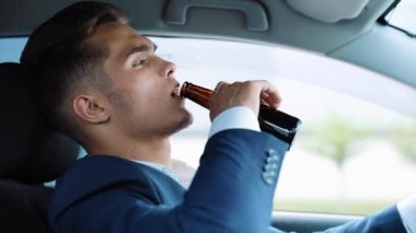 Genç işadamı arabada bira içiyor. Kötü bir anlaşma ya da kötü haber yüzünden morali bozuk bir adam. Direksiyondaki sarhoş sürücü. Sarhoşluk, araba kullanma ve başarısız iş konsepti