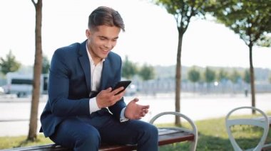 Mutlu genç işadamı Smartphone vasıl seyir kutluyor tezahürat. İşte iyi haber. Başarı ve başarı, spor, akıllı telefon app kavramı bahis kazancı,