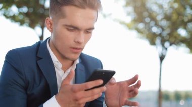 Mutlu genç işadamı Smartphone vasıl seyir kutluyor tezahürat. İşte iyi haber. Başarı ve başarı, spor, akıllı telefon app kavramı bahis kazancı,