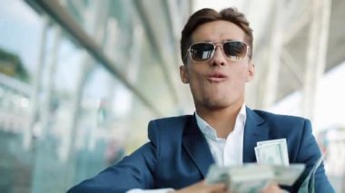 Genç işadamı dağılım sokakta dolar mutlu. Bu office center yanında, ağır çekim yer almaktadır. Başarılı bir iş veya Piyango kazanma
