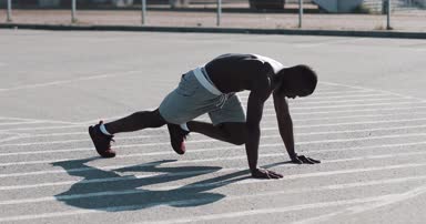 Atletik Afrikalı-Amerikalı adam hızlı bir şekilde spor stadyum yakınında sokakta açık tahta içinde bacaklarını kır. Fitness, sağlık, spor, vücut geliştirme, aktif yaşam tarzı