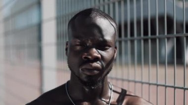 Kendinden emin ve kızgın Afrikalı-Amerikalı adam kameraya - açık arıyor. Uyuşturucu kaçakçısı, tutuklu veya suç adam bir kılavuz karşı ayakta. Yasadışı, cinayet, suç, hırsızlık, uyuşturucu. Yakın çekim