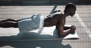 Bir tahta sokak eğitim, performans atletik Afrikalı-Amerikalı adam. Genç spor adamı egzersiz Spor Stadyumu yakınındaki egzersiz adam. Çapraz uygun eğitim. Kaslı zenci adam açık iterek