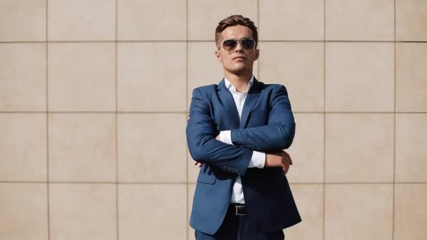 Portrait d'un homme d'affaires heureux à succès avec les mains croisées regardant dans la caméra. Il se tient près du bâtiment de bureaux. Concept d'entreprise réussie, style, personne heureuse et réussie — Video