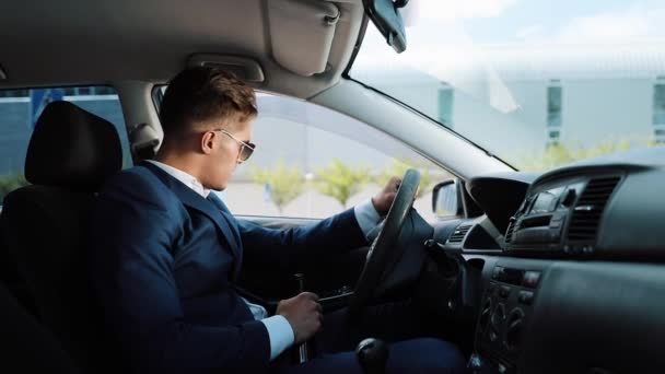 Deprimido e muito chateado jovem empresário no carro. Um homem bebe álcool ao volante problemas na vida profissional ou pessoal — Vídeo de Stock