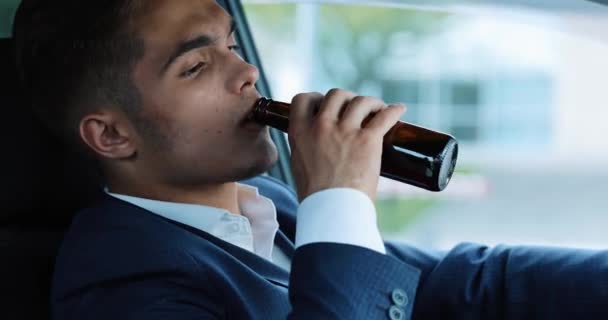 Молодой бизнесмен пьет пиво в машине. Человек в плохом настроении из-за плохой сделки или плохих новостей. Пьяная, управляемая и неудачная бизнес-концепция — стоковое видео