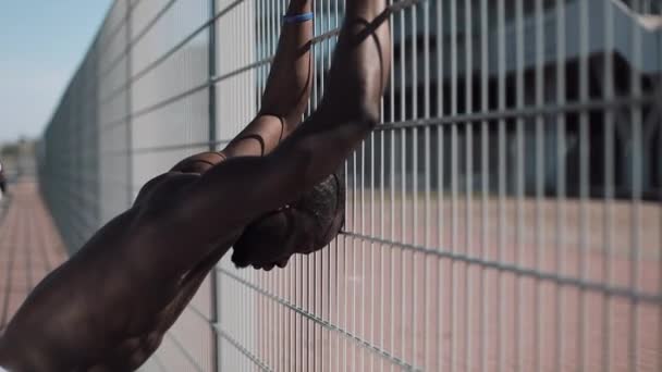 En ledsen, deprimerad, utmattad African American står av ett rutnät på gatan — Stockvideo