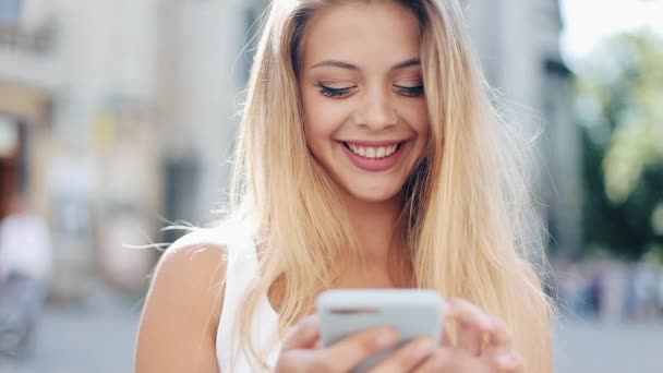 Hermosa mujer joven utilizando la aplicación de tecnología de teléfonos inteligentes en las calles de la ciudad vieja. Comunicación, tecnología, estilo de vida. Marco vertical para dispositivos móviles — Vídeos de Stock