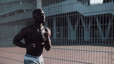 Afro-Amerikan erkek atlet atlet açık havada çalışan. Football stadium yakınındaki cadde boyunca koşan atletik siyah adam. Sağlıklı yaşam - çalışan. Yaz saati. Adam egzersiz, fitness ve