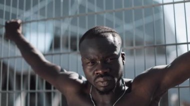 Kendinden emin ve kızgın Afrikalı-Amerikalı adam kameraya - açık arıyor. Uyuşturucu kaçakçısı, tutuklu veya suç adam bir kılavuz karşı ayakta. Yasadışı, cinayet, suç, hırsızlık, uyuşturucu. Yakın çekim