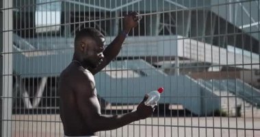 Bir Afrikalı-Amerikalı çalıştırmak bir Maratondan sonra istirahat ediyor. Koşma, Yarı maraton, maraton, Olimpiyat oyunları, susuzluk, Fitness, koşu, motivasyon eğitimi, rekabet,