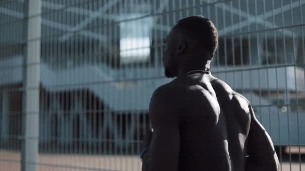 Ung African American fighter körs på gatan nära sport stadium och svänga händer som boxning i slow motion — Stockvideo