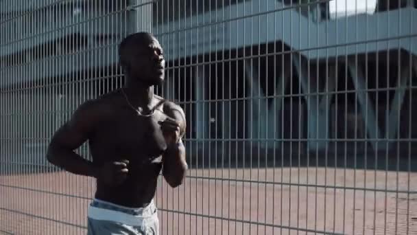 非洲裔美国男性运动员跑到户外跑步 运动黑衣男子在足球场附近的街道上奔跑 健康的生活方式 夏季时间 男子运动 健身和 — 图库视频影像