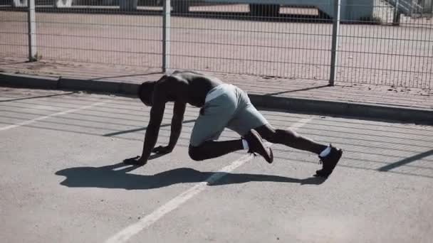 Benen atletische African American man snel buigen in front plank in de straat in de buurt van het Sportpaleis. Fitness, gezondheid, sport, bodybuilding, actieve levensstijl. Slow motion — Stockvideo