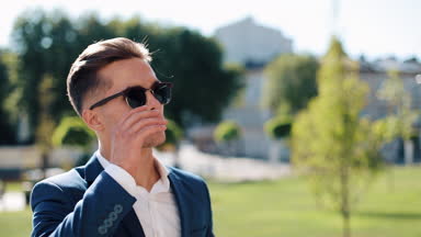 Açık duran güneş gözlüklü genç başarılı iş adamı. O gözlükleri ve kameraya bakarak kapalı alır. Şık zarif kıyafeti. Olma patronu, başarılı yaşam tarzı