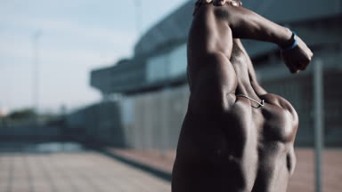 Afro-Amerikan erkek athlet sabah egzersiz açık havada yakın yavaş hareket güneş kadar yapar. Egzersiz ayakta Spor Stadyumu yakınında sokakta. Sağlıklı yaşam irade motivasyon kavramı