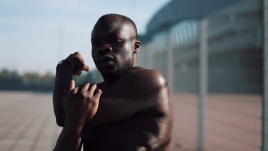 Afro-Amerikan erkek athlet sabah egzersiz açık havada yakın yavaş hareket güneş kadar yapar. Egzersiz ayakta Spor Stadyumu yakınında sokakta. Sağlıklı yaşam irade motivasyon kavramı
