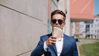 Genç işadamı dağılım sokakta dolar mutlu. Bu office center yanında, ağır çekim yer almaktadır. Para yağmur. Başarılı bir iş veya Piyango kazanma