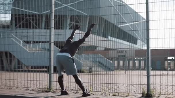 African American mannelijke athlet doet ochtend oefening buiten dicht omhoog slowmotion zon glans. Training staande op de straat in de buurt van sportstadion. Gezonde levensstijl wilskracht motivatie concept — Stockvideo