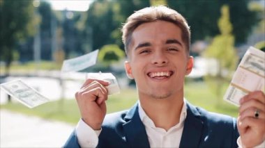 Mutlu genç işadamı para büyük bir miktar onun elinde tutan. Ofis merkezi veya banka yakınlarında sokakta duruyor. İş tarzı, kazanç, para, başarı, kariyer