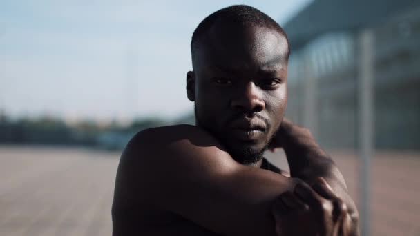 African American mannelijke athlet doet ochtend oefening buiten dicht omhoog slowmotion zon glans. Training staande op de straat in de buurt van sportstadion. Gezonde levensstijl wilskracht motivatie concept — Stockvideo