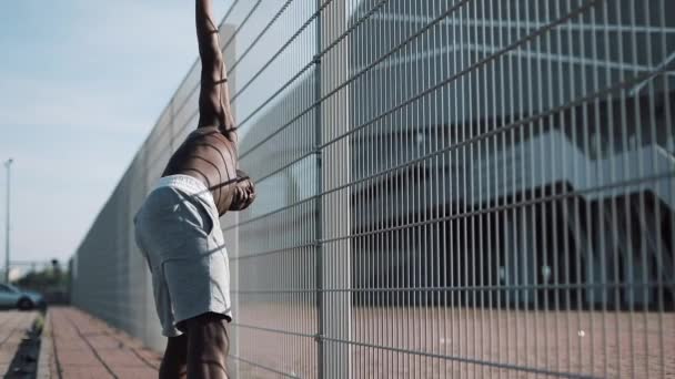 African American athlet mężczyzna robi rano ćwiczenia na zewnątrz Zamknij się powolny ruch słońca blask. Ćwiczenie stojąc na ulicy w pobliżu Stadion sportowy. Zdrowy styl życia będzie moc koncepcja motywacji — Wideo stockowe
