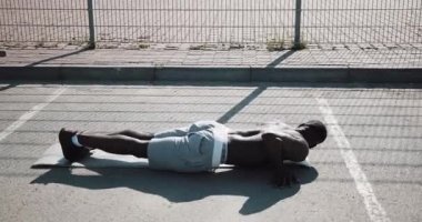 Sokak egzersiz. Şınav ve açık havada spin egzersiz yapan atletik Afro-Amerikan erkek. Bir zenci spor stadium yanında oynuyor. Egzersiz, fitness, motivasyon, çalışan