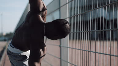 Afro-Amerikan erkek athlet sabah egzersiz açık havada yakın yavaş hareket güneş kadar yapar. Egzersiz ayakta Spor Stadyumu yakınında sokakta. Sağlıklı yaşam irade motivasyon kavramı