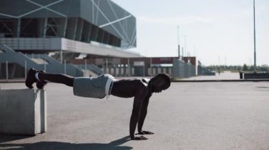 Sokak egzersiz. Şınav ve açık havada spin egzersiz yapan atletik Afro-Amerikan erkek. Bir zenci spor stadium yanında oynuyor. Egzersiz, fitness, motivasyon, çalışan