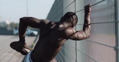 Afro-Amerikan erkek athlet sabah egzersiz açık havada yakın yavaş hareket güneş kadar yapar. Egzersiz ayakta Spor Stadyumu yakınında sokakta. Sağlıklı yaşam irade motivasyon kavramı