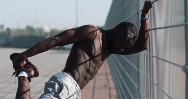Афро-американських чоловіче спортивне робить вранці вправи на відкритому повітрі закрити вгору повільному сонце світить. Тренування стоячи на вулиці поблизу спортивний стадіон. Здоровий спосіб життя сила волі мотивації концепції — стокове відео