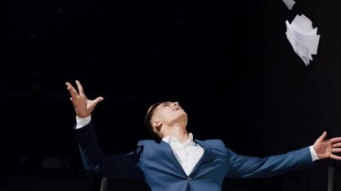 Siyah elbiseli mutlu genç işadamı belgeleri ofis binası karşı açık dışarı atar. Ağır çekim video. İş, kağıt işi, yayın, tatil, sözleşme, yaşam biçimi