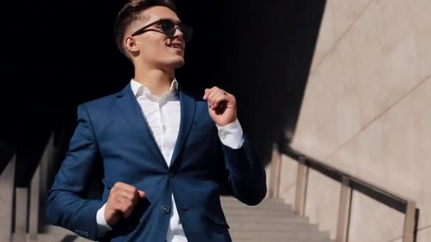 Young happy businessman celebrating and funny dancing directly into the camera celebrating his achievement and success. Slow motion — Stock Video