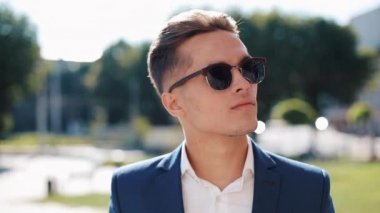 Yanlara açık havada seyir güneş gözlüklü genç işadamı