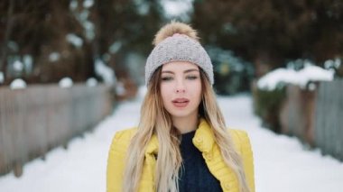 Sarı Ceket zarflarda muhteşem kadın kendini kar üzerinde dolaşıyor. Kar yağıyor. Açık havada. güzel genç kadın bir kışın yürüyor