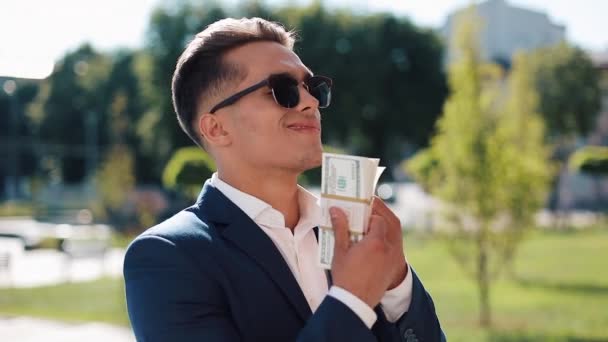 Joven hombre de negocios con dinero. Un hombre exitoso está feliz por el dinero. El dinero no huele. Negocios exitosos. Disparo en la épica roja — Vídeo de stock