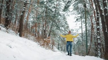 Kış şapkalı güzel kadın kar sahiptir ve ormanın içinde kar üzerinde ayakta dışında etrafında fırtınası