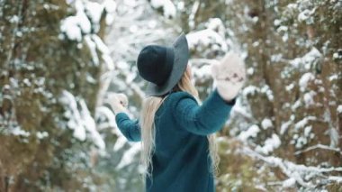 Bayan yeşil palto ve şapka etrafında kış ormanda fırtınası