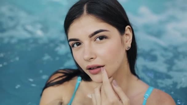 Menina bonita em maiô sexy em pé na piscina, câmera lenta. Close-up. Retrato de sexy erótico molhado menina na piscina posando para a câmera — Vídeo de Stock