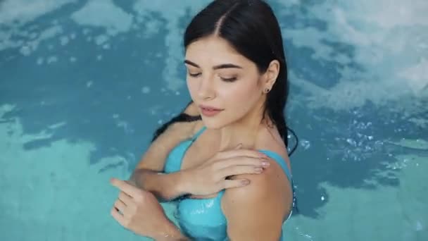 Krásná dívka v sexy plavky, stojící v bazénu, zpomaleně. Detail. Portrét sexy erotické mokré dívka ve fondu vystupují do kamery — Stock video