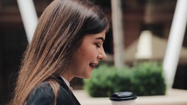 Joven empresaria profesional que camina por la calle urbana con un smartphone y bebe café. Concepto: nuevo negocio, comunicación, banquero. Afuera, cámara lenta — Vídeos de Stock