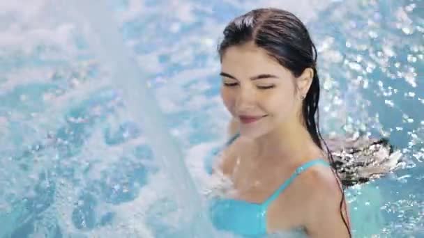 Young sexy woman enjoys water in swimming pool. Aqua aerobics, aquamassage, swimming pool — Stock Video