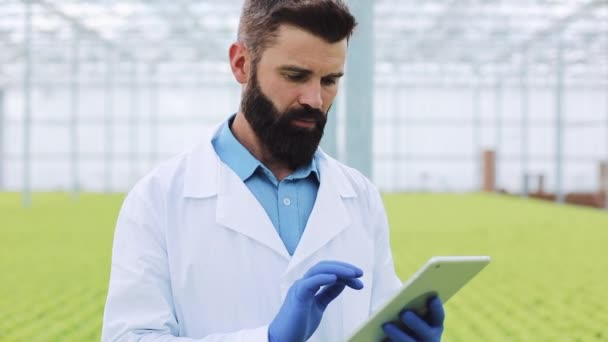 Portrét zemědělský inženýr ve skleníku pracuje na digitálním tabletu — Stock video